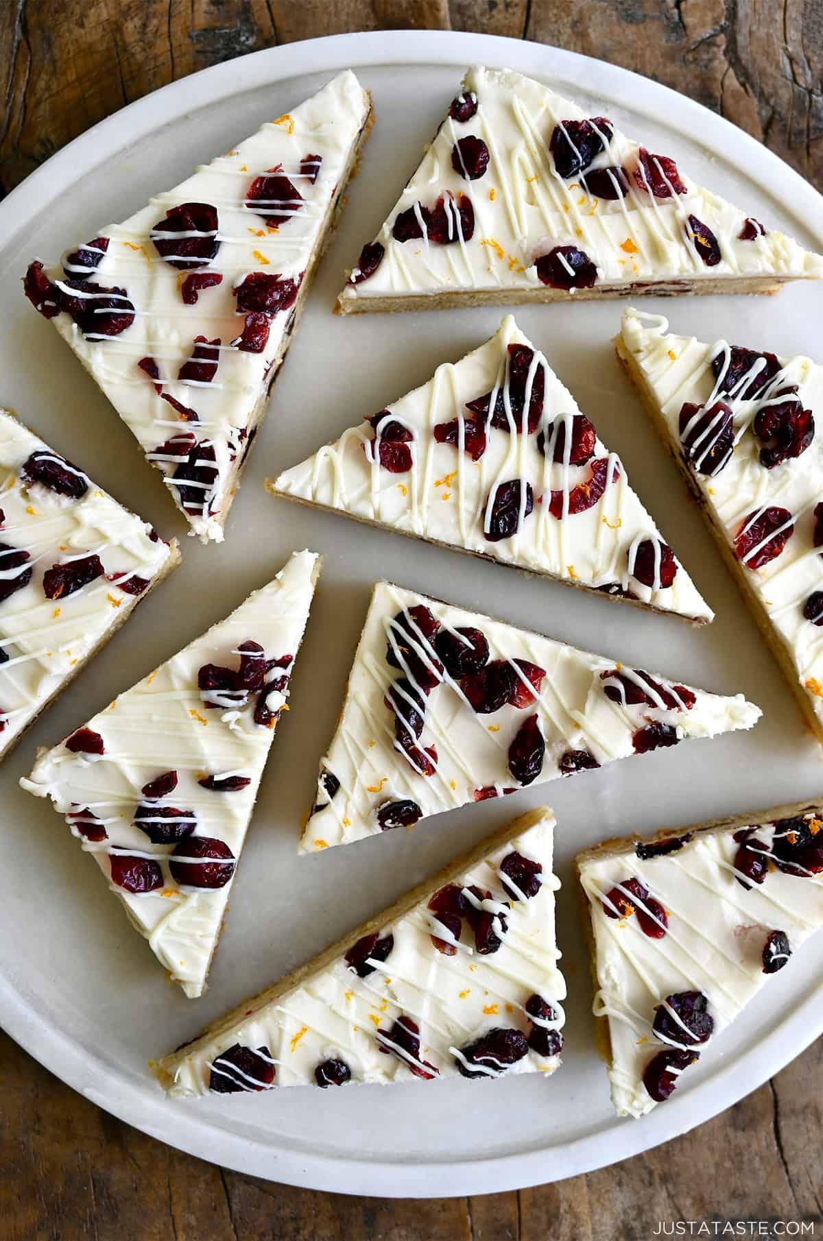 Festive cranberry bliss bars with white chocolate drizzle on a holiday platter