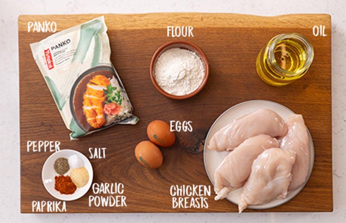 ingredients for garlic chicken breast laid out on a wooden cutting board