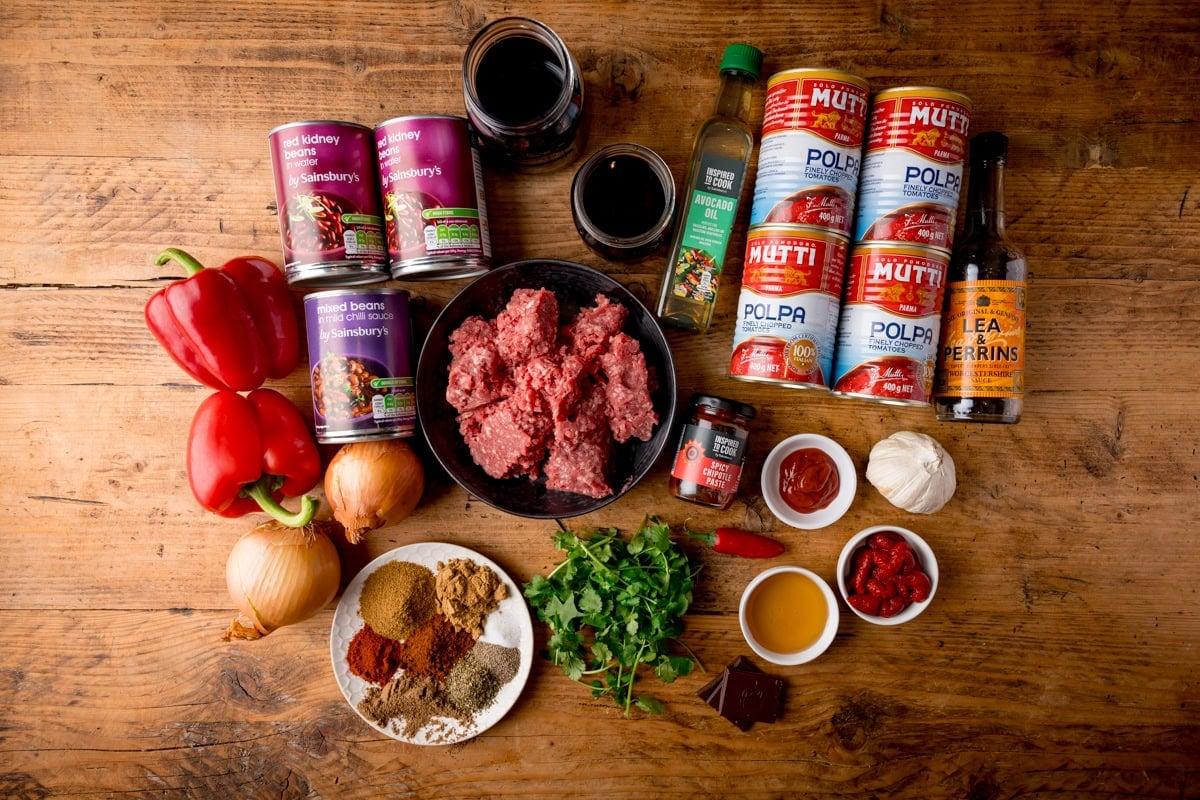 Ingredients for homemade chili laid out on a wooden table