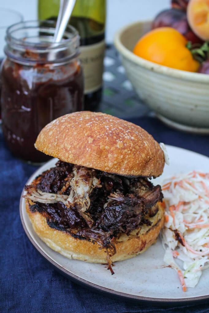 close up shot of pulled pork with blackberry sage bbq sauce being shredded