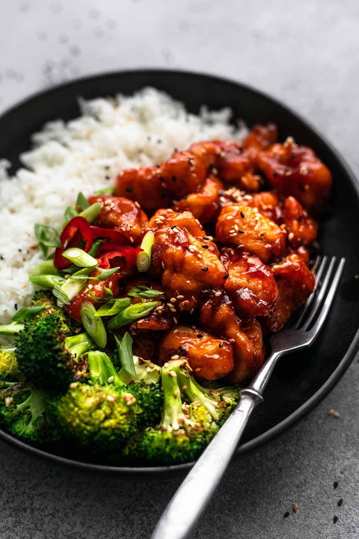close-up of sticky chicken on rice with vegetables