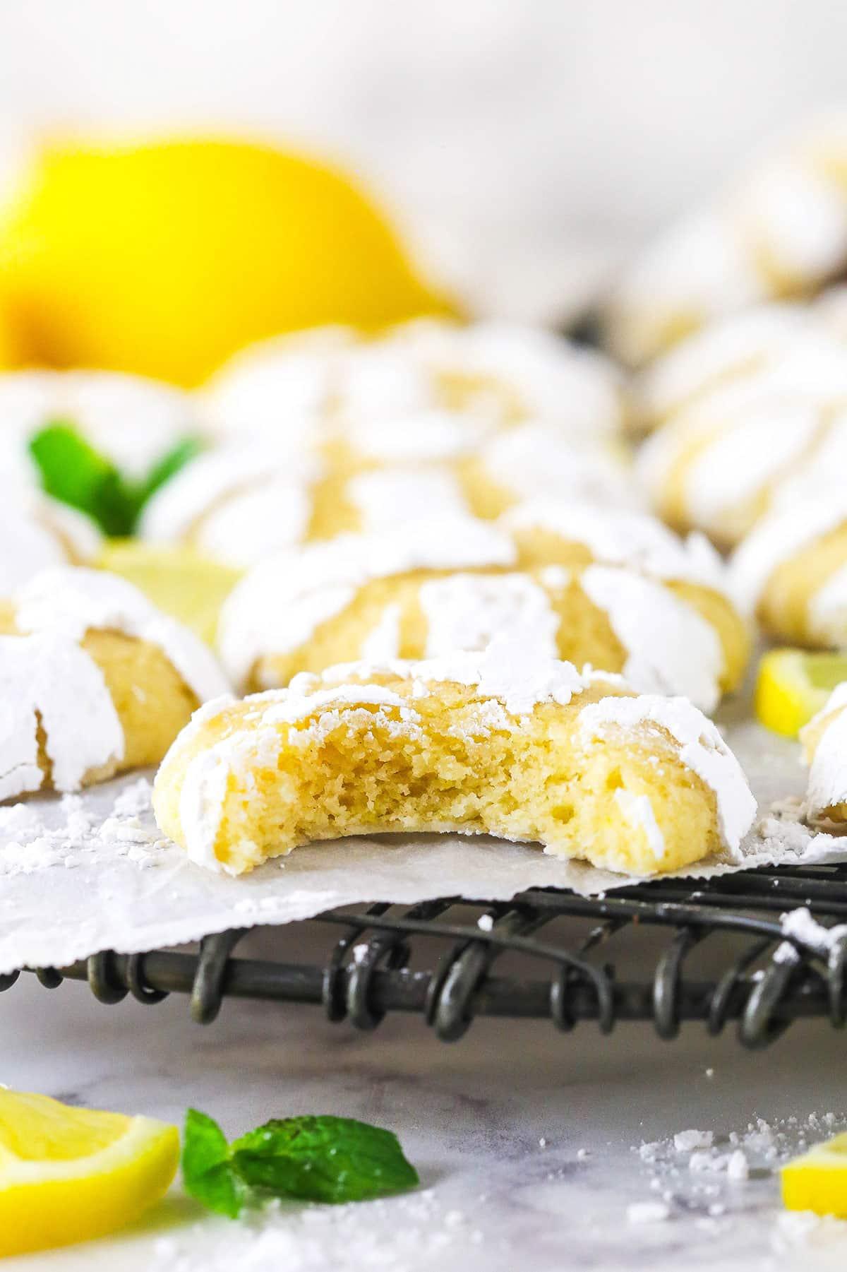 bright yellow lemon cookies with powdered sugar and fresh lemon zest on a cooling rack