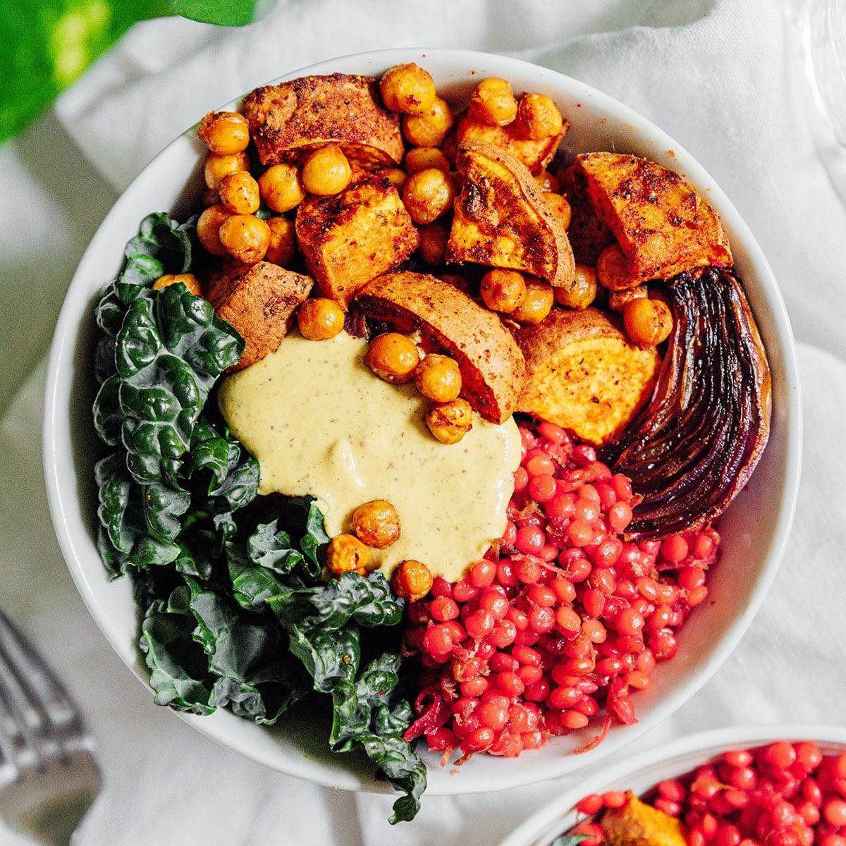 a vibrant, healthy slow-cooked veggie bowl, rustic wooden table, natural light