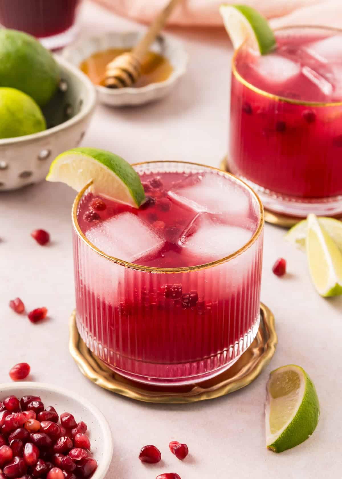 vibrant sparkling pomegranate mocktail in a festive glass with mint and lime garnish, holiday setting