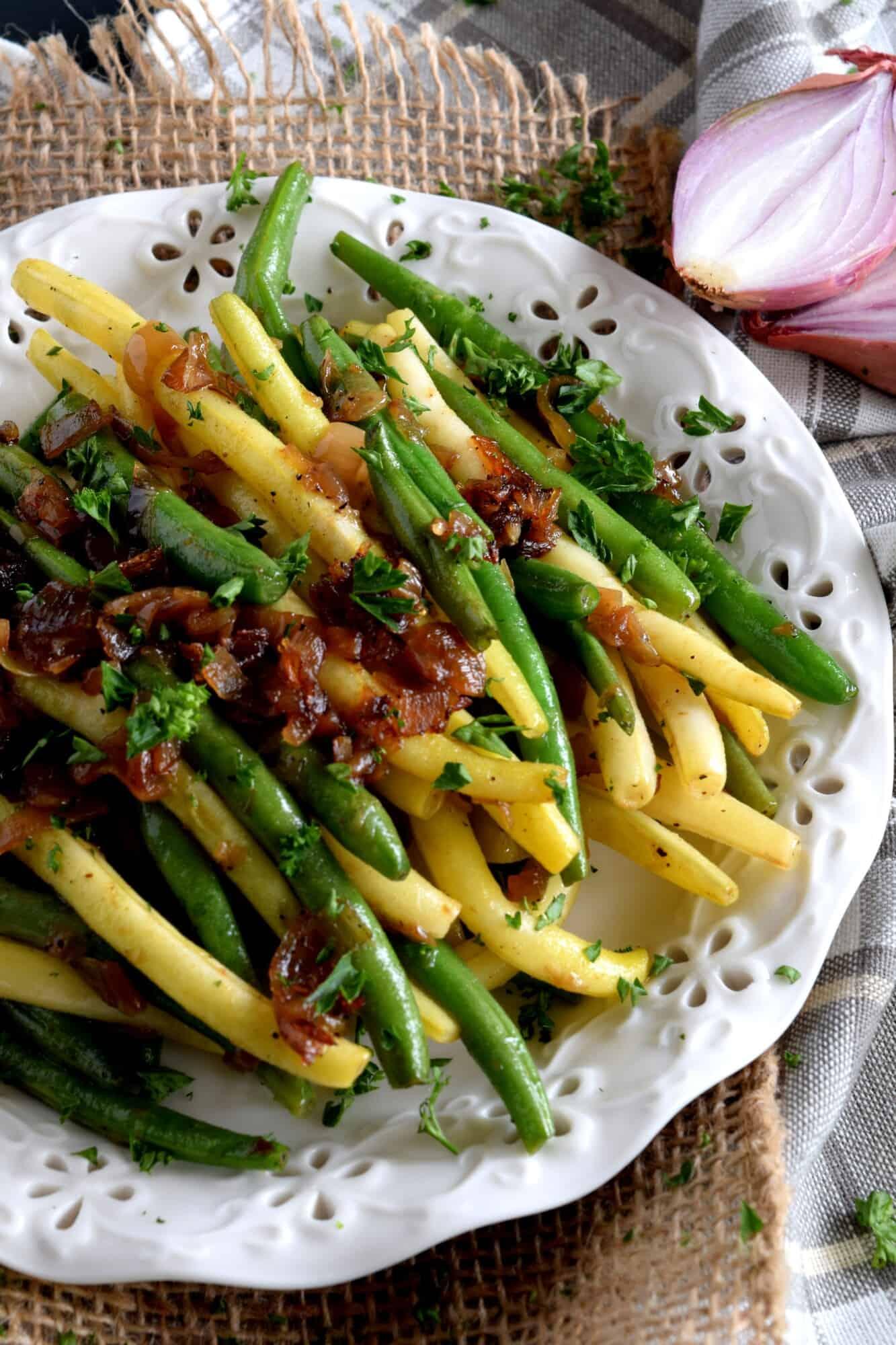 sizzling green beans and caramelized shallots in melted butter in a non-stick skillet, steam rising