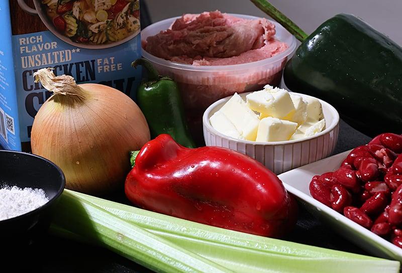 Hands quickly preparing ingredients for chili-fired skillet beef, showing chopped onions and bell peppers on a cutting board.