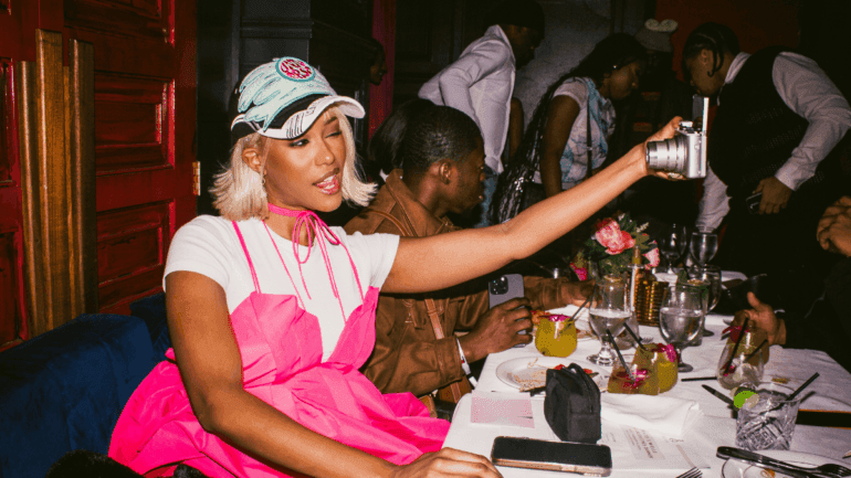 friends toasting with mugs of festive apple drink at a cozy Friendsgiving dinner