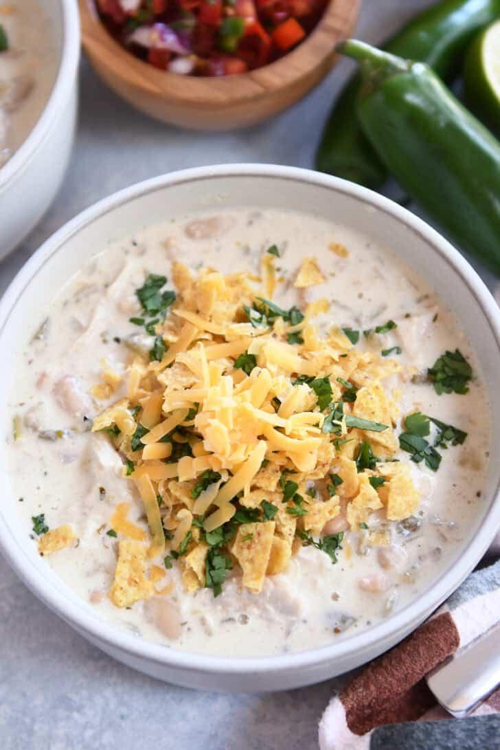 creamy white chicken chili in a rustic bowl, garnished with cilantro and sour cream