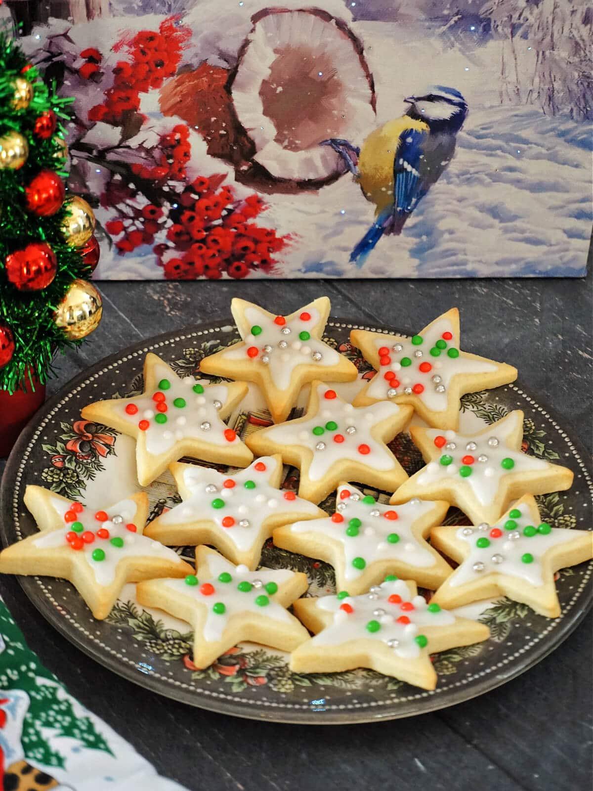 Festive star-shaped sugar cookies with vibrant, shiny glazes on a cooling rack, decorated for a party