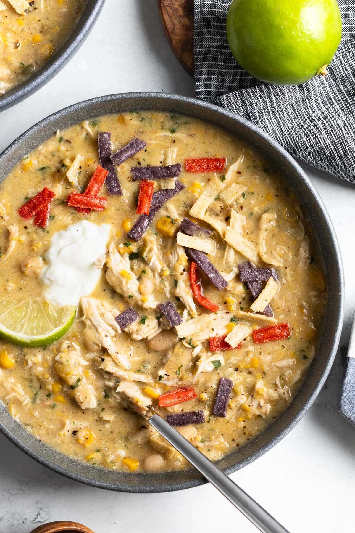 A pot of simmering white chicken chili on a stove, steam rising