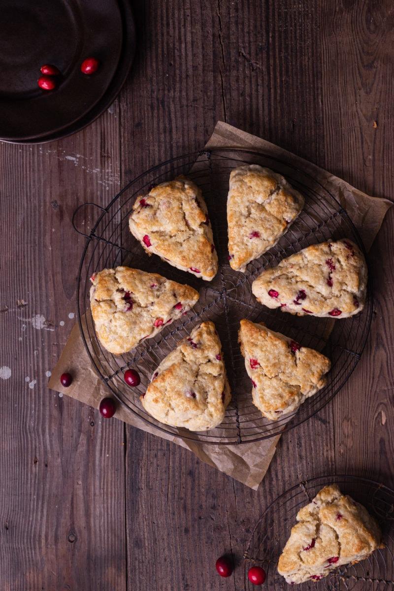 overhead shot of fresh cranberries, oranges, and sugar on a wooden board