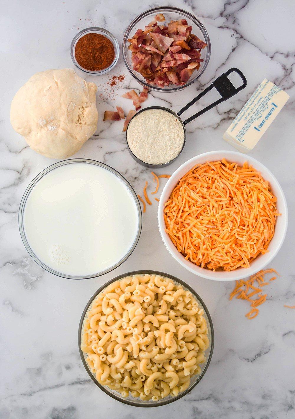 ingredients for pizza mac and cheese arranged on a table