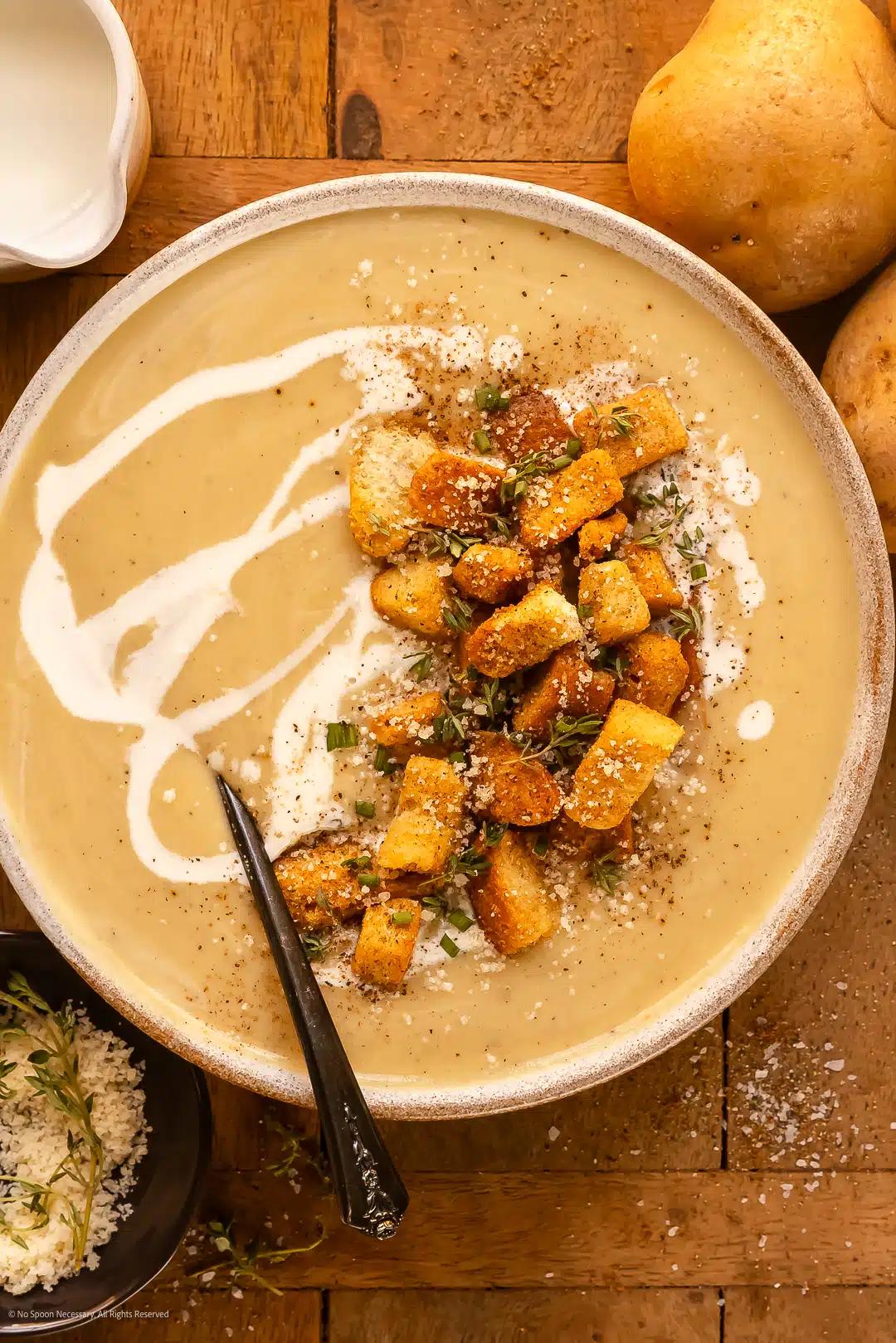 Cooked potato soup being stirred in a large pot, steam rising