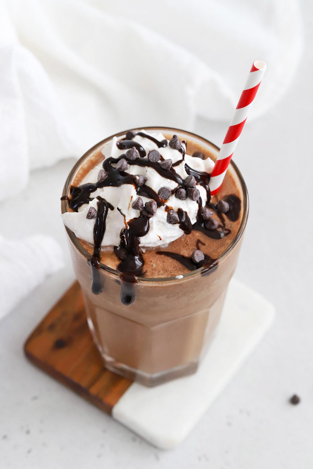 almond milk hot chocolate with a swirl of vegan whipped cream and chocolate shavings