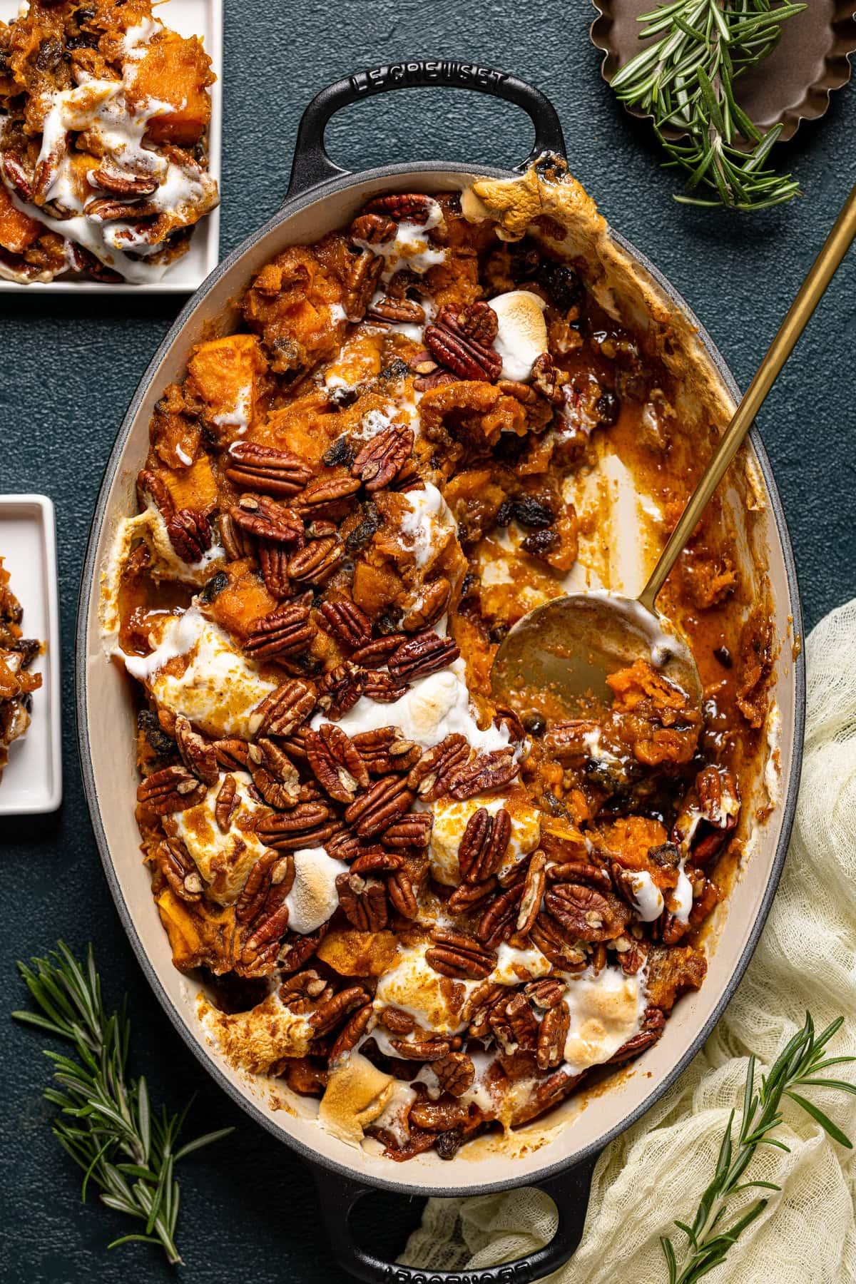 Overhead shot of the finished maple sweet potato casserole, still in the baking dish, with a serving spoon