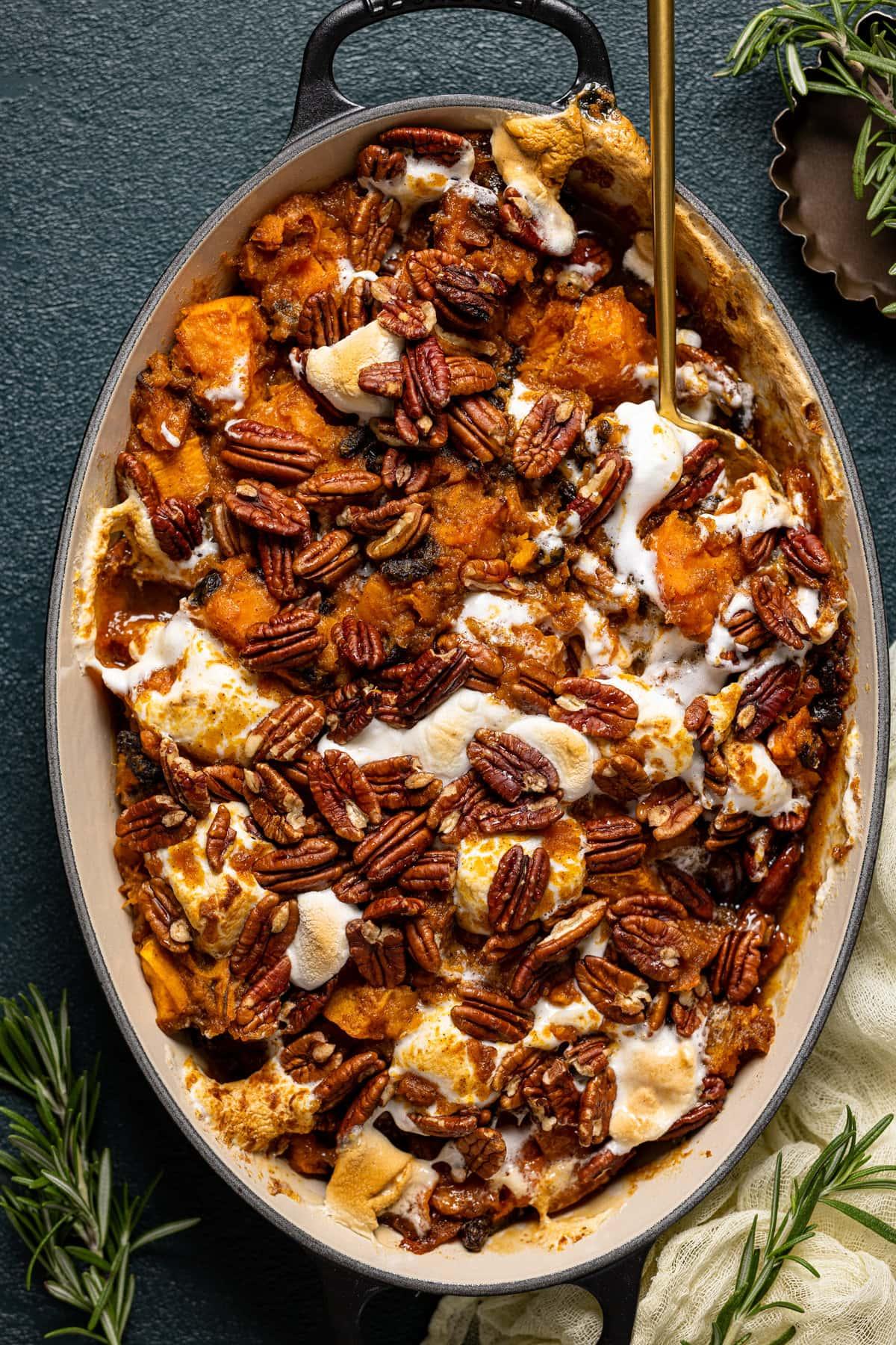 Ingredients for maple sweet potato casserole laid out on a kitchen counter: sweet potatoes, maple syrup, butter, brown sugar, pecans