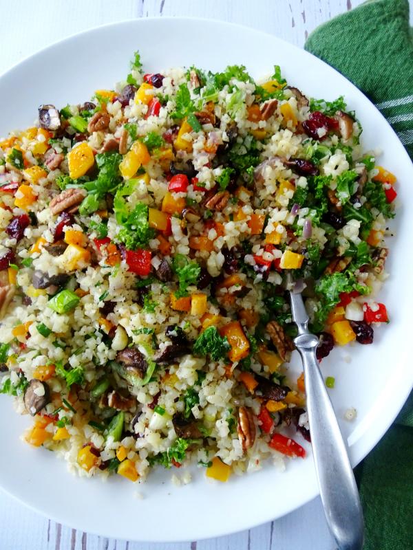 Top-down shot of a fully cooked cauliflower rice pilaf, garnished with fresh herbs