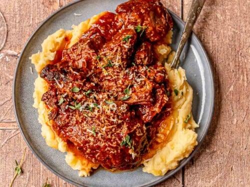 Cozy kitchen scene with a slow cooker gently simmering, aromatic steam rising from a chili beef roast, warm lighting, a family laughing in the background