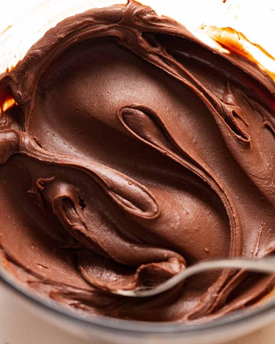 Close-up of creamy dark chocolate ganache being mixed in a bowl