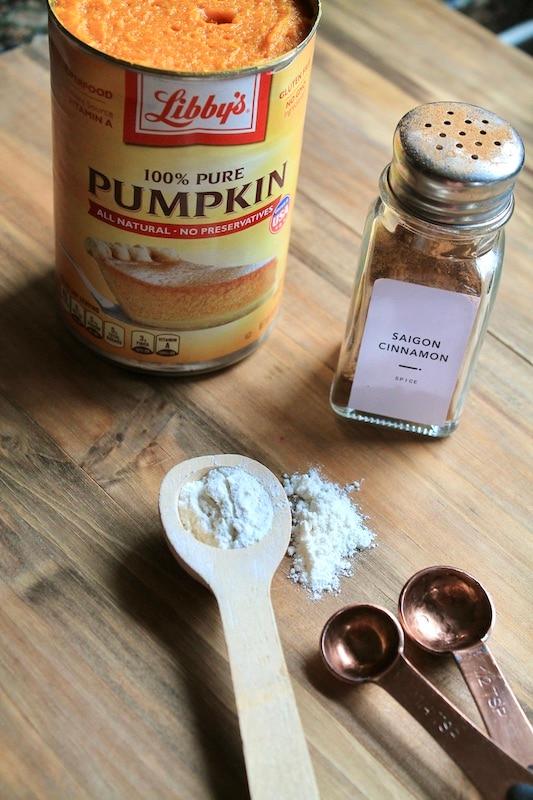 an open can of libbys pumpkin puree next to measuring cups and spices