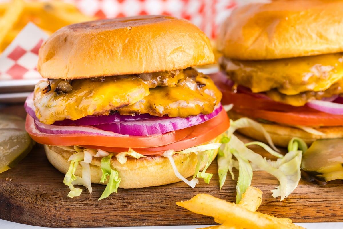 Perfectly assembled smash burger with secret sauce, cheese, and fresh toppings on a wooden board