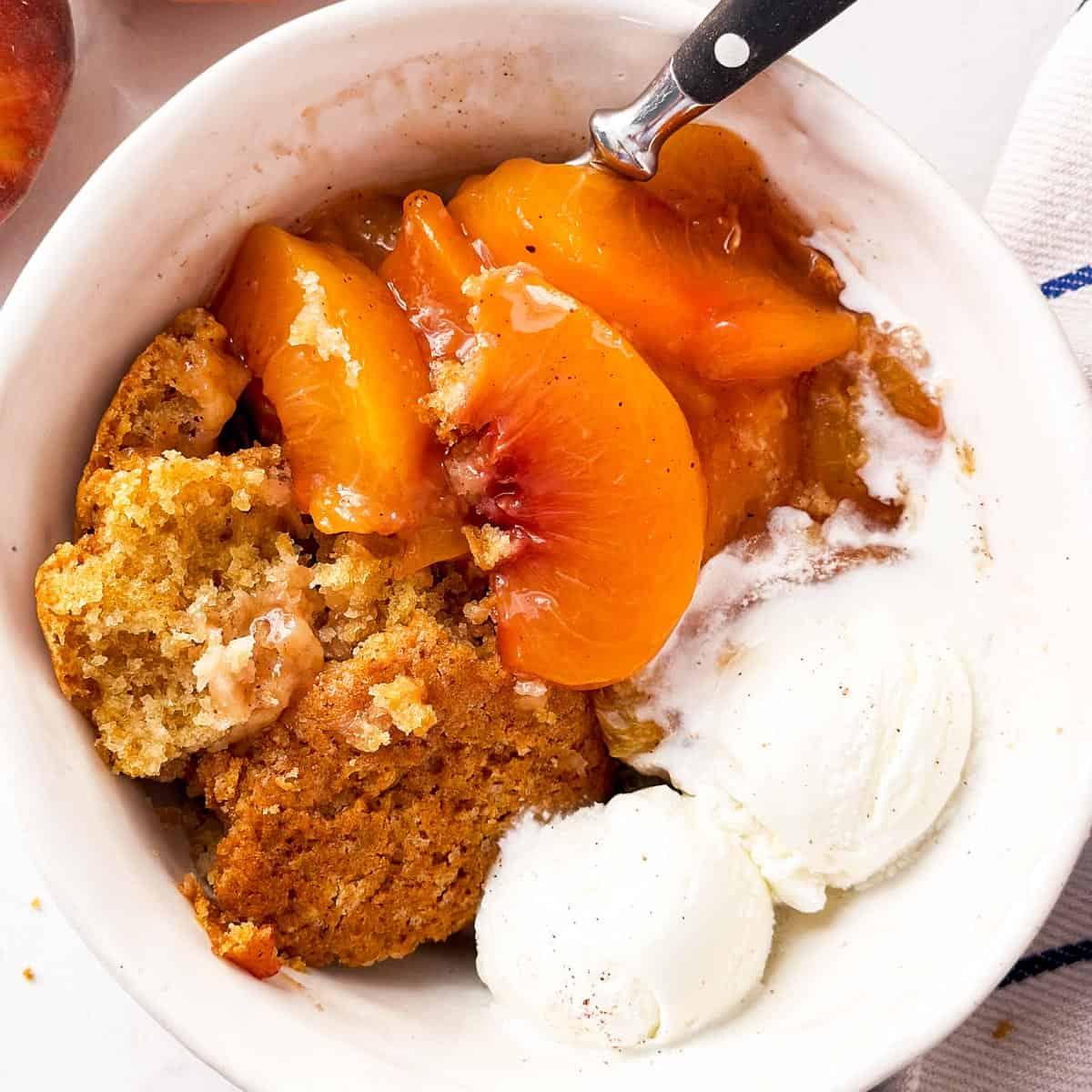 close-up shot of a slice of peach cobbler with tuberose garnish