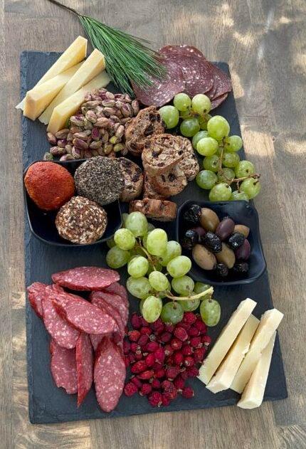 Elegant charcuterie board with a variety of cured meats, artisan cheeses, fresh grapes, and figs