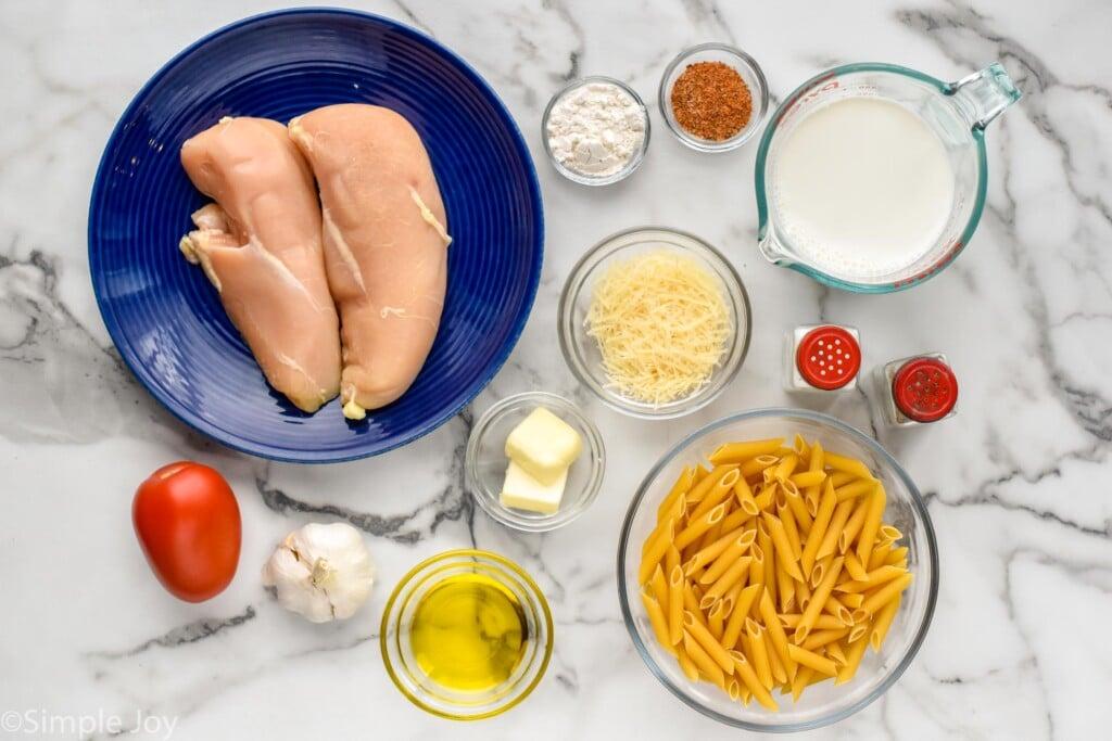 Overhead shot of all ingredients for Creamy Cajun Chicken Pasta laid out on a kitchen counter
