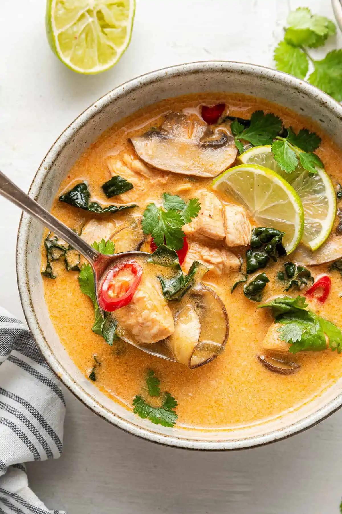 bowl of coconut chicken quinoa curry garnished with cilantro