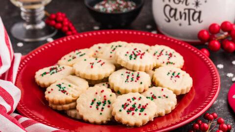 Assortment of finished shortbread cookies with various icing designs, some simple, some elaborate, arranged artfully