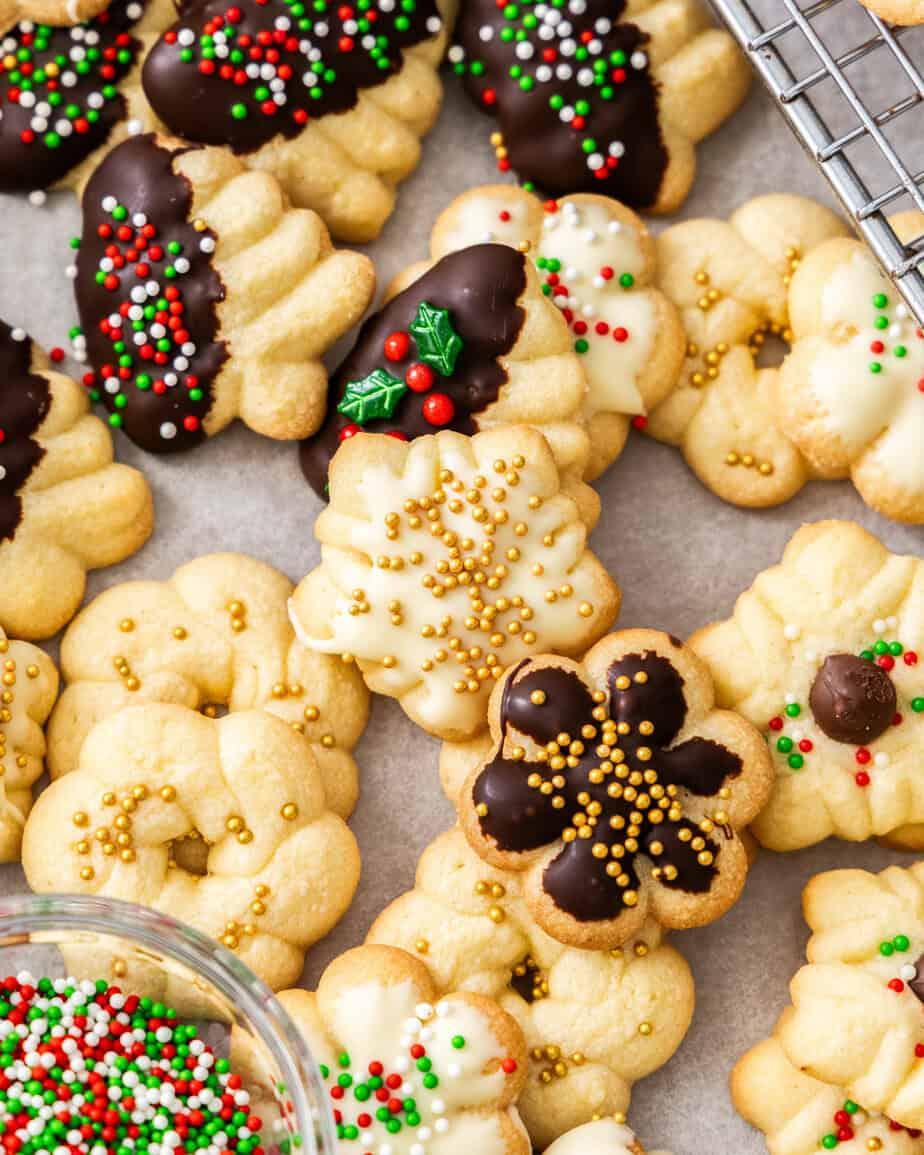 Various festive shapes of spritz cookies on a baking sheet before baking