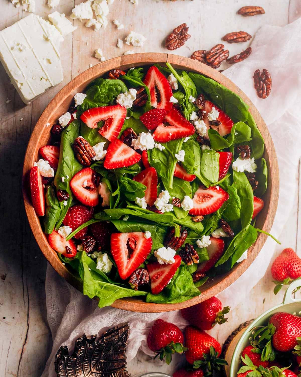 overhead view of strawberry spinach salad with marjoram flowers