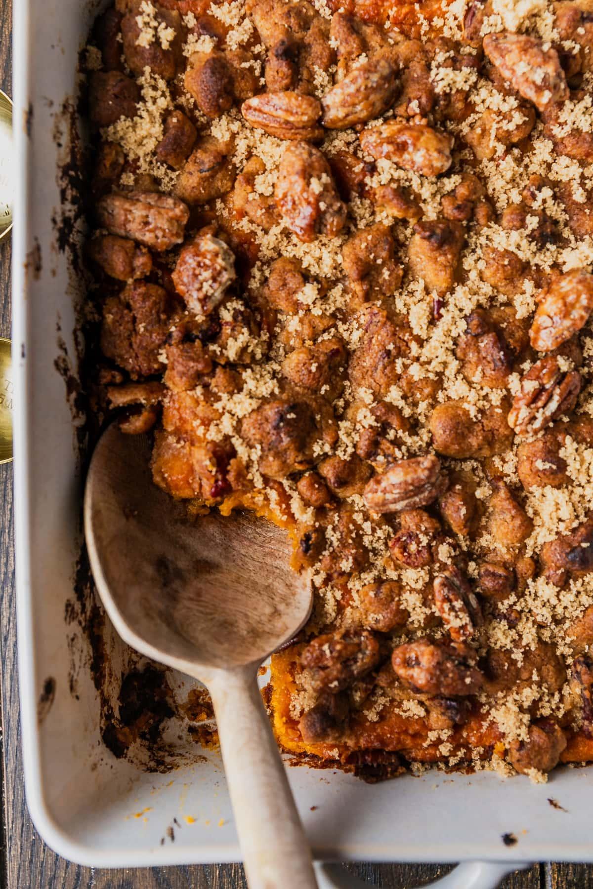 Rustic overhead shot of a prepared sweet potato casserole dish, before baking, showing the mashed sweet potato base and crumbly topping.