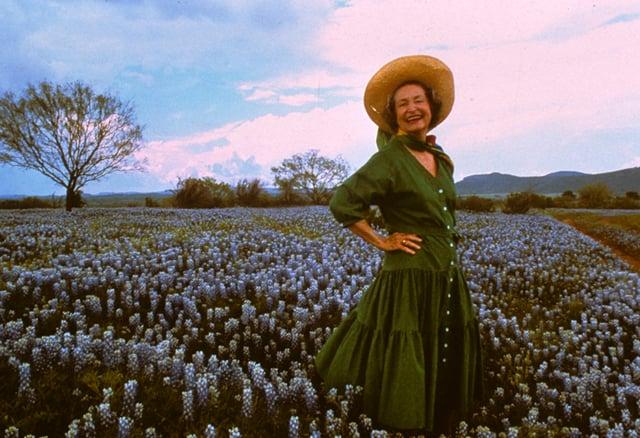 woman appreciating a field of wildflowers on Earth Day
