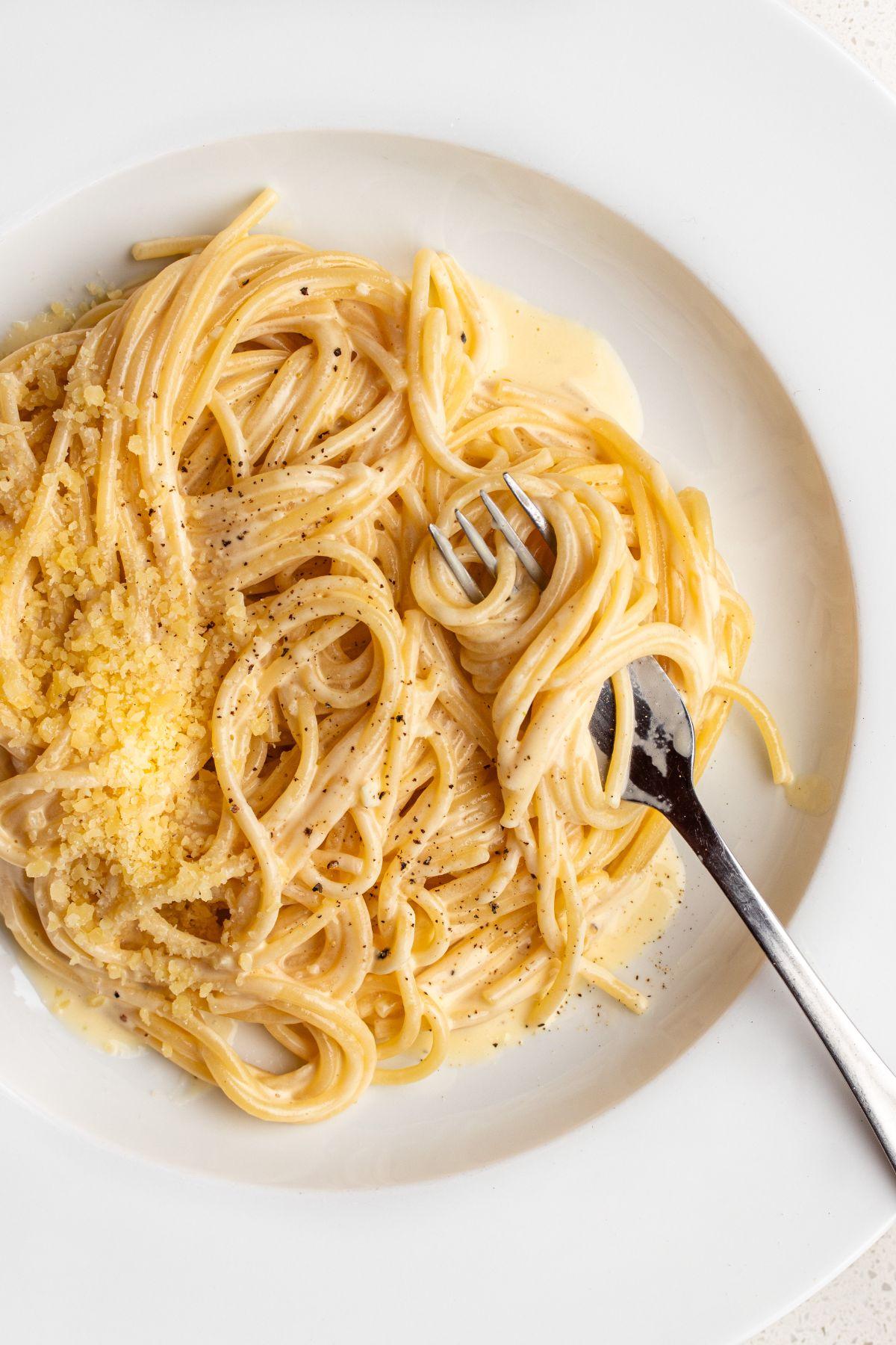 close-up shot of creamy garlic parmesan pasta twirled around a fork