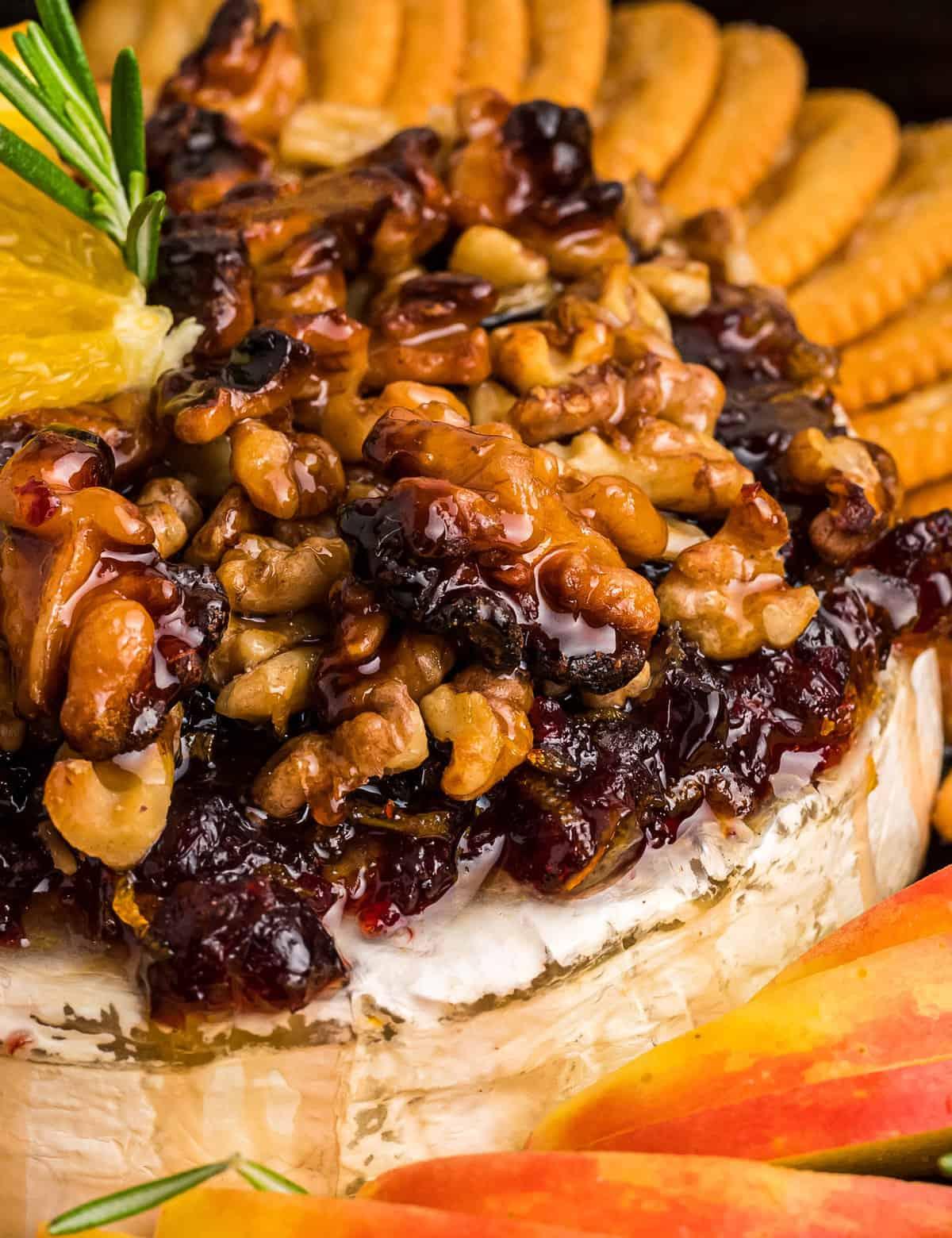 Warm baked brie with honey, nuts, and cranberries on a festive Thanksgiving table