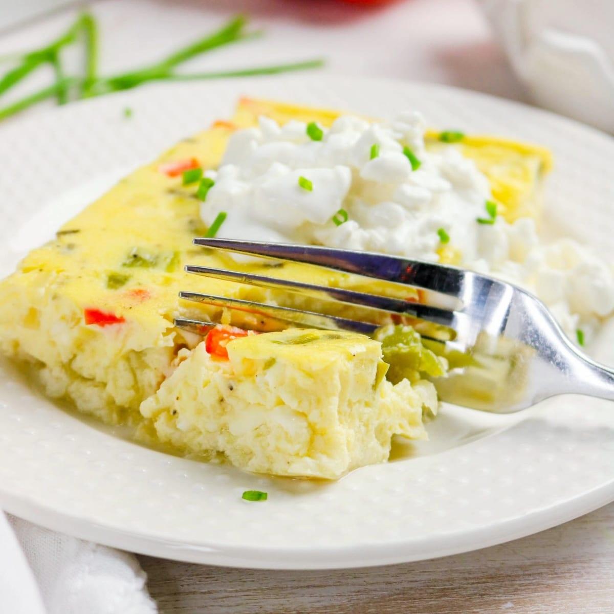 a perfect slice of cheesy egg bake on a white plate with a fork, steam gently rising, garnished with fresh chives, close up shot