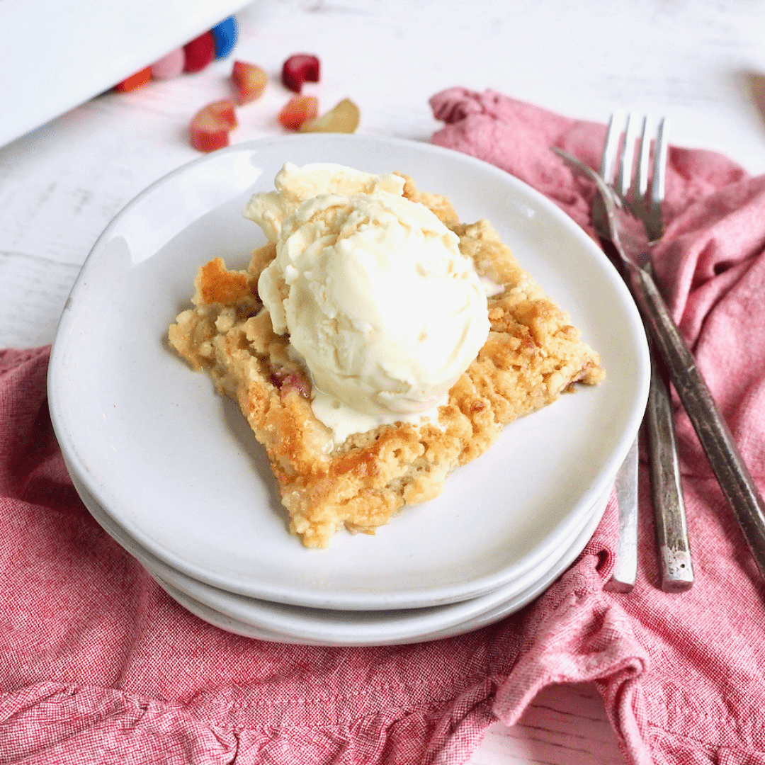 close-up shot of a slice of allspice aroma rhubarb dump cake with vanilla ice cream
