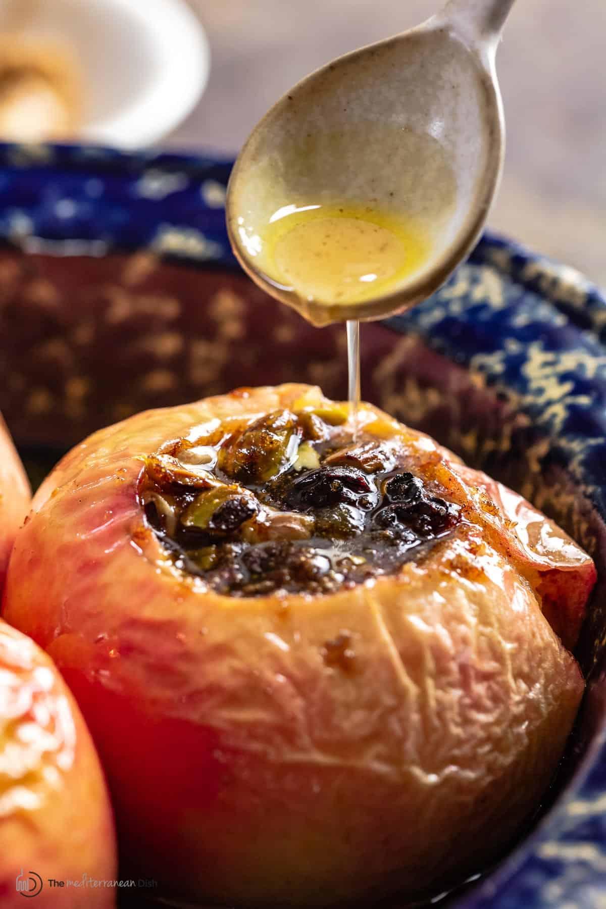 honey baked apples with almonds being taken out of the oven