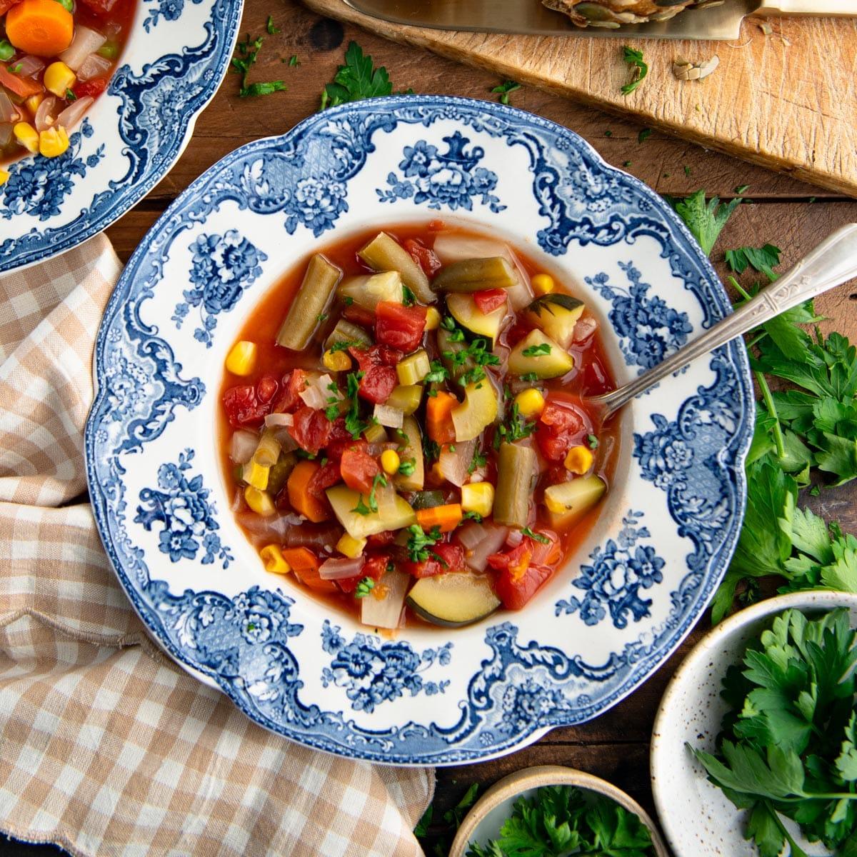 overhead shot of a large pot of vegetable soup simmering on a stovetop