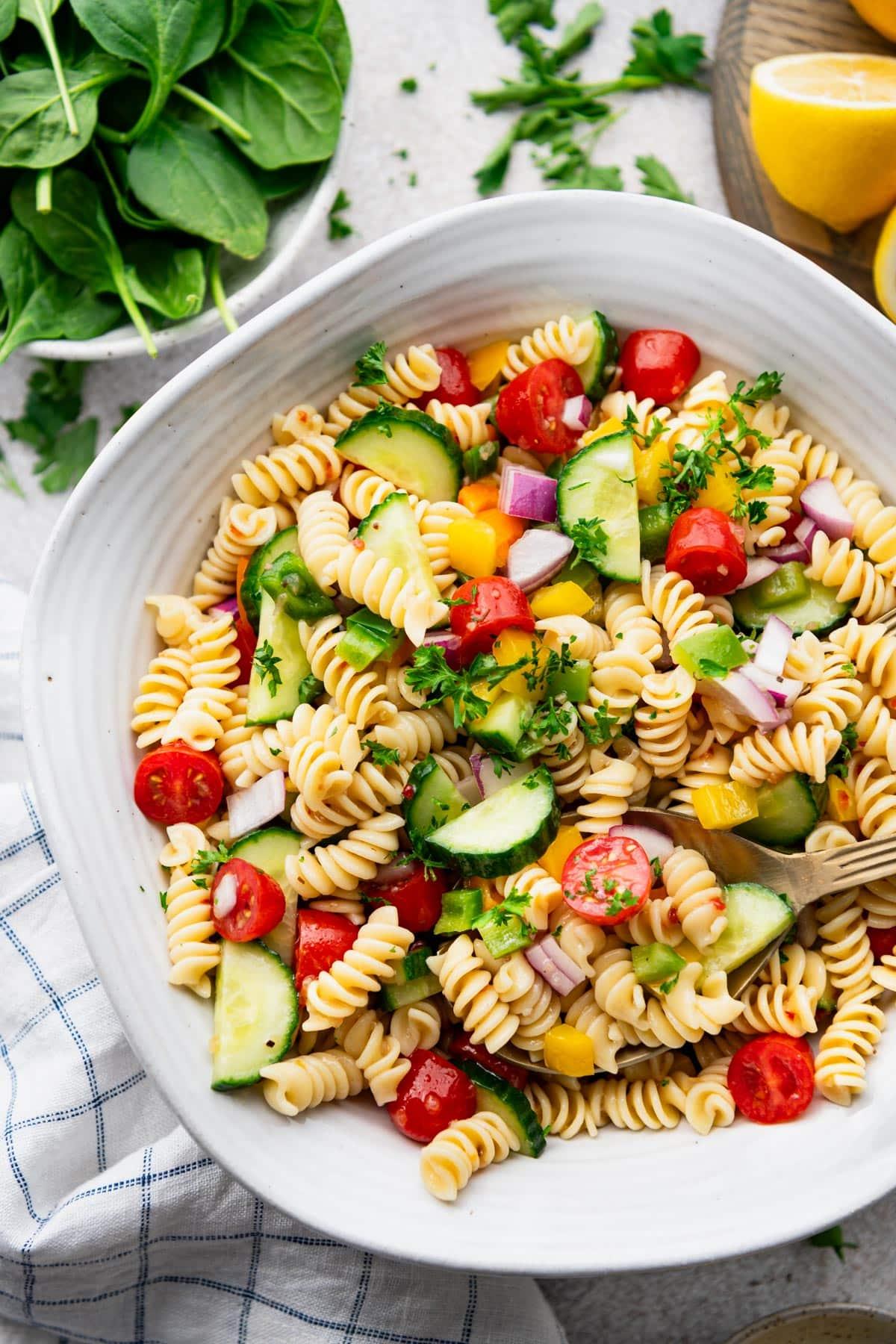 Close-up shot of various pasta salad dressings in small bowls.
