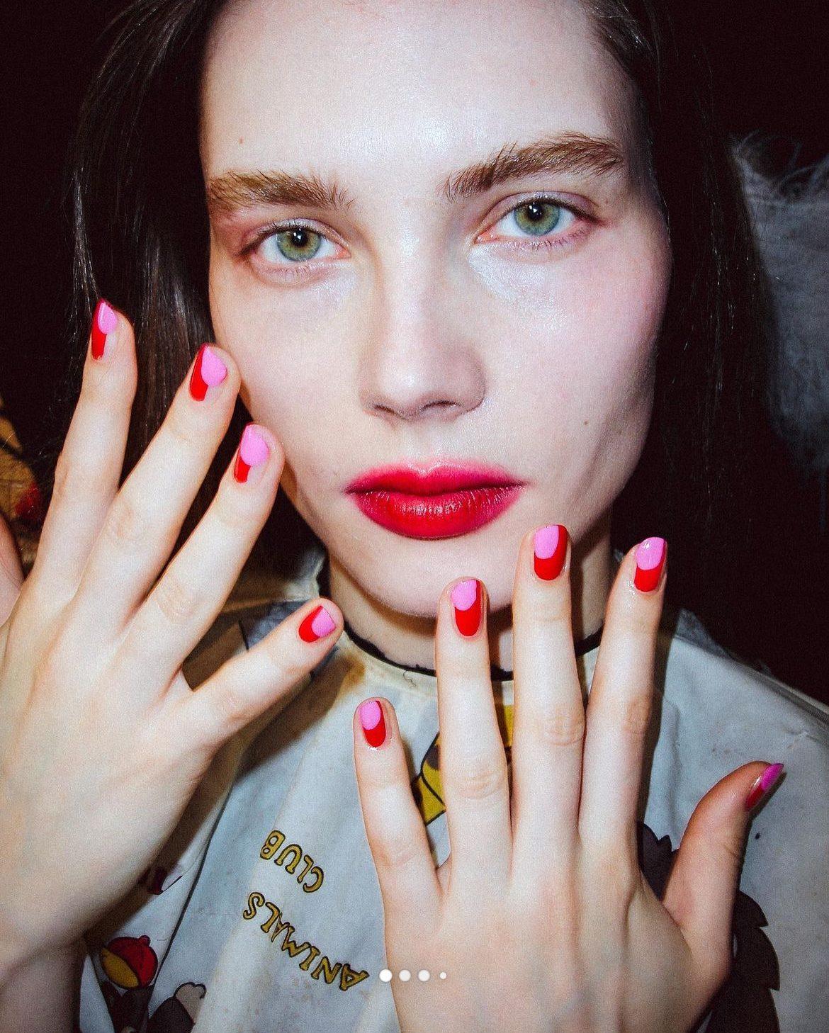 woman smiling confidently, showcasing her colorful spring nail art