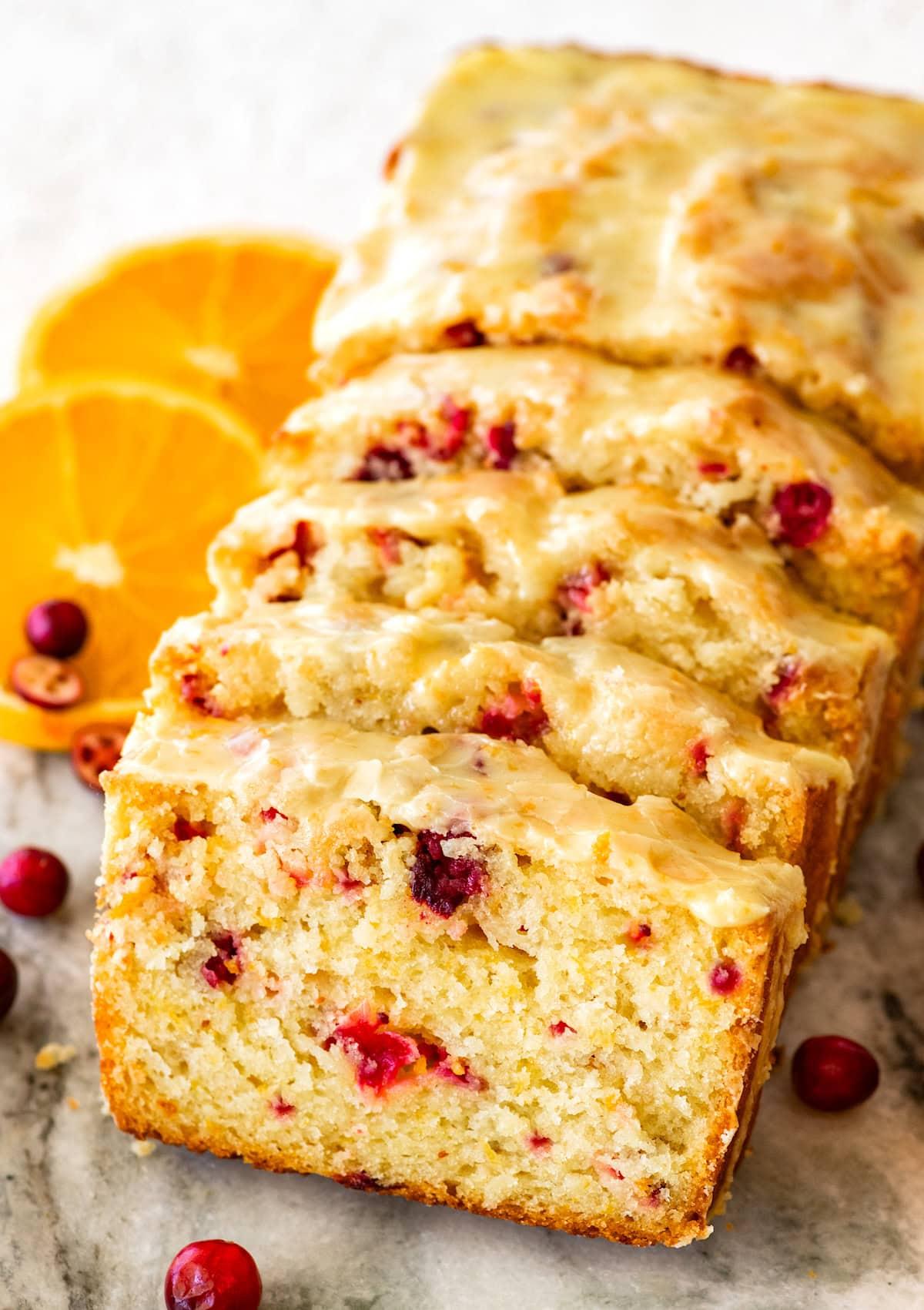 Homemade cranberry orange bread cooling on a wire rack with steam gently rising, bright morning light.