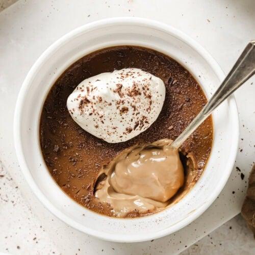 Bowl of melted dark chocolate and heavy cream with espresso powder, steaming gently