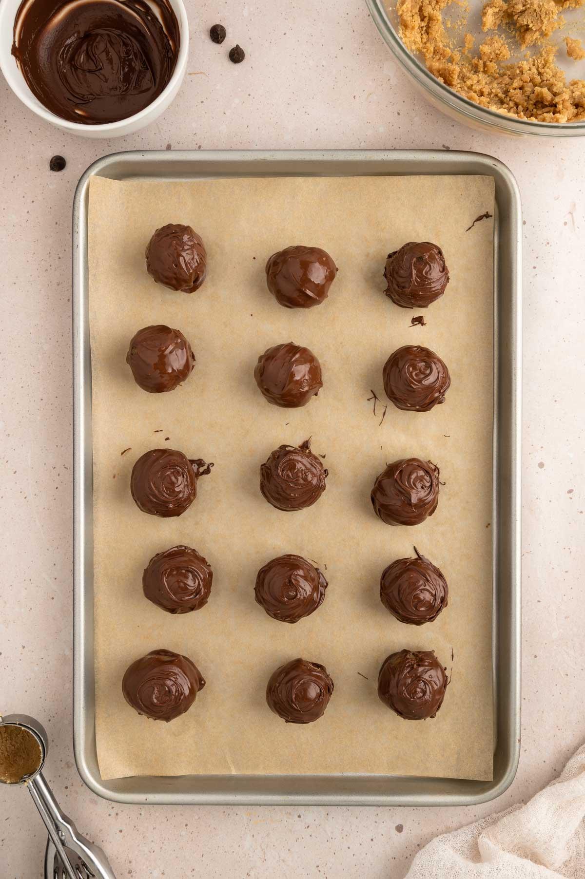close-up of raw double chocolate cookie dough balls on a baking sheet, ready for the oven