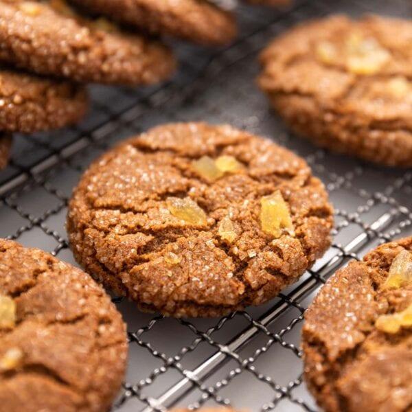 Warm, crinkled molasses cookies dusted with sugar on a cooling rack