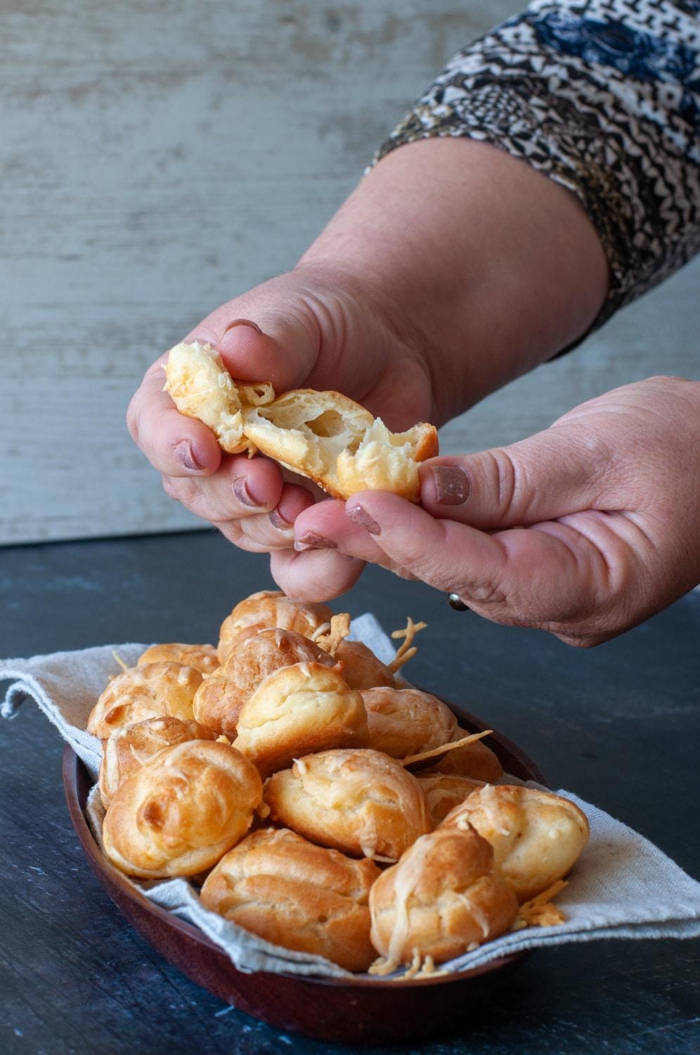 hand holding a golden savory cheese puff steam