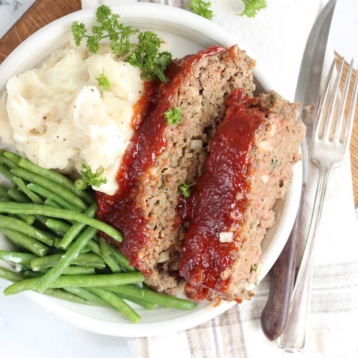 homemade meatloaf with mashed potatoes and green beans
