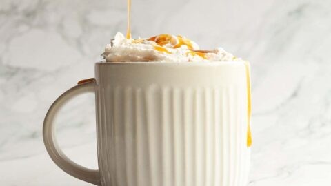 Close-up of a mug of salted caramel hot chocolate with whipped cream and caramel swirl