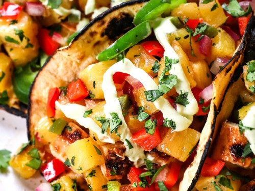 vibrant pineapple chicken tacos with fresh cilantro, lime wedges, and a side of tropical fruit salsa